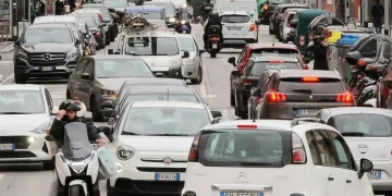 Coda di automobili in strada urbana, traffico intenso di veicoli