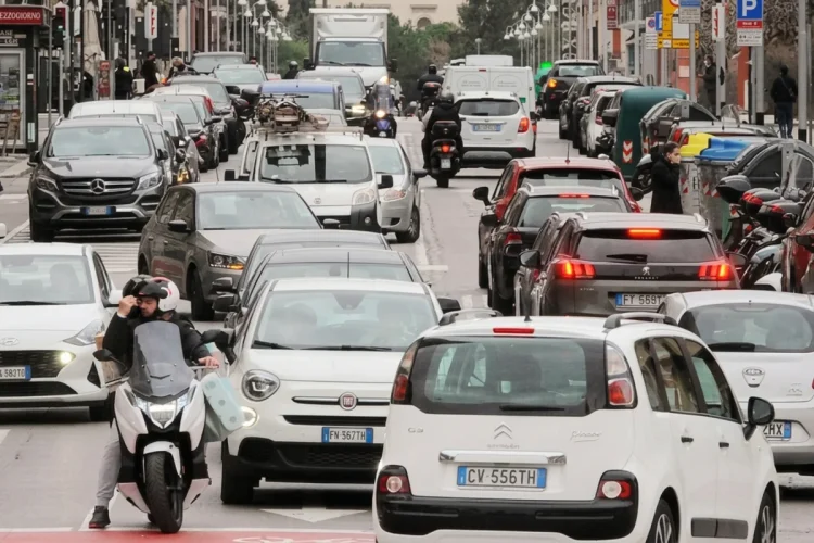 Coda di automobili in strada urbana, traffico intenso di veicoli