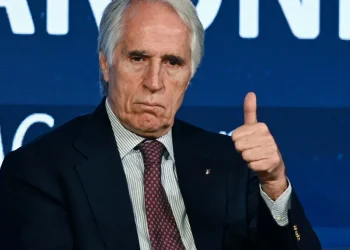 Giovanni Malagò in giacca e cravatta fa un gesto di approvazione.