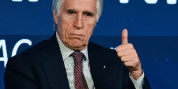 Giovanni Malagò in giacca e cravatta fa un gesto di approvazione.