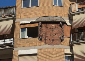 Facciata di un edificio danneggiato con intonaco crollato, mattoni a vista. Roma, esplosione fa crollare parte di un muro durante la disinfestazione di un nido di vespe