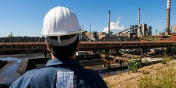 Operaio ILVA osserva lo stabilimento siderurgico di Taranto