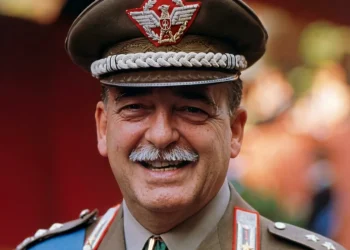 Generale Carlo Alberto Dalla Chiesa in uniforme sorride, con medaglie e cappello.