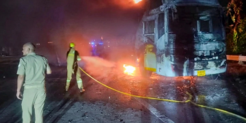 Vigile del fuoco spegne autobus in fiamme su autostrada di notte. India, arrestati l'autista e il bigliettaio dopo il rogo di un bus: almeno nove morti