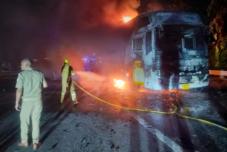 Vigile del fuoco spegne autobus in fiamme su autostrada di notte. India, arrestati l'autista e il bigliettaio dopo il rogo di un bus: almeno nove morti