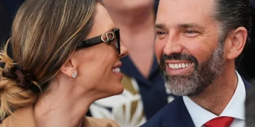 Donald Trump Jr. sorride a Kimberly Guilfoyle con occhiali da sole.