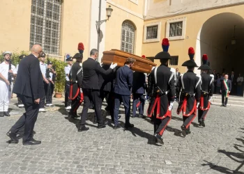 Carabinieri in alta uniforme portano una bara di legno per funerali in Campidoglio