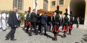Carabinieri in alta uniforme portano una bara di legno per funerali in Campidoglio