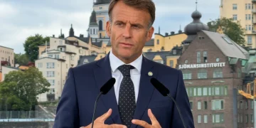 Emmanuel Macron parla davanti ai microfoni durante un evento pubblico.