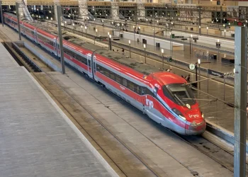 Treno rosso ad alta velocità Iryo fermo in stazione sui binari