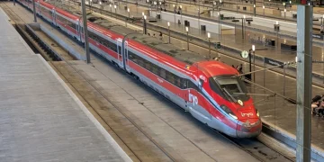 Treno rosso ad alta velocità Iryo fermo in stazione sui binari