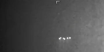 Oggetto volante non identificato con luci brillanti su sfondo scuro