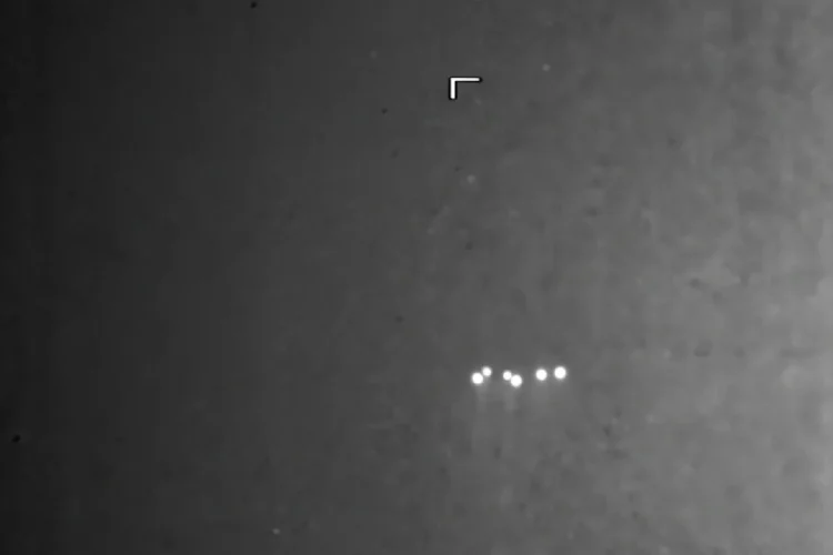 Oggetto volante non identificato con luci brillanti su sfondo scuro