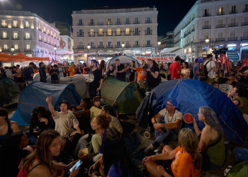 Persone in protesta accampate con tende in una piazza di Madrid. Madrid, i manifestanti si accampano in tenda contro gli sfratti nella piazza principale della città