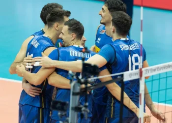 Giocatori della nazionale italiana di pallavolo abbracciati in campo durante la partita.