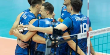Giocatori della nazionale italiana di pallavolo abbracciati in campo durante la partita.