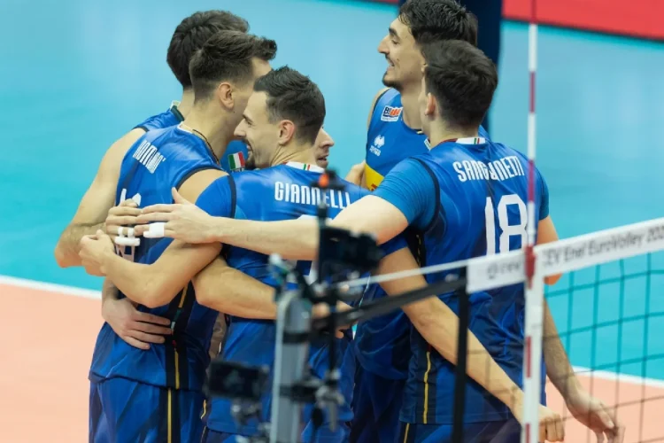 Giocatori della nazionale italiana di pallavolo abbracciati in campo durante la partita.