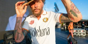 Jovanotti con cappello di paglia e maglietta SoleLuna su palco all'aperto