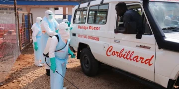 Operatori sanitari con tute protettive spruzzano disinfettante in Congo.