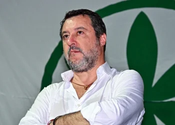 Matteo Salvini in camicia bianca con logo verde della Lega