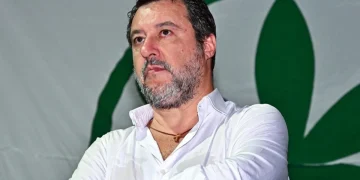 Matteo Salvini in camicia bianca con logo verde della Lega