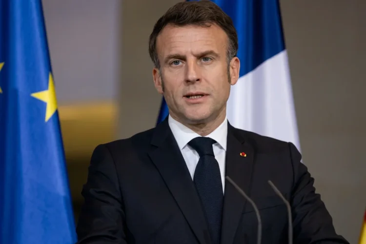 Emmanuel Macron parla davanti bandiera europea e francese.