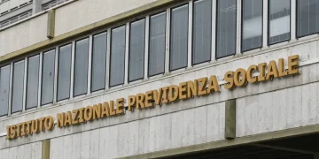 Insegna INPS su edificio, lettere oro in rilievo, finestre riflettenti