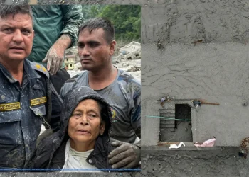 Soccorritori nepalesi e donna anziana salvata dal fango in Nepal