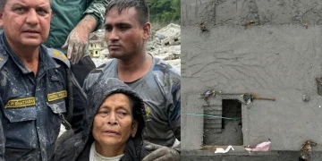 Soccorritori nepalesi e donna anziana salvata dal fango in Nepal