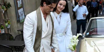 Damiano David e Dove Cameron camminano, lei tiene bouquet bianco, Montalcino.