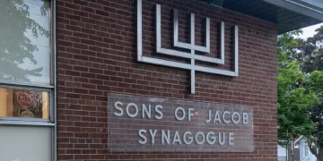 Esterno della sinagoga Sons of Jacob con menorah sulla facciata di mattoni.