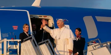 Papa Francesco saluta dall'aereo con assistenti di volo
