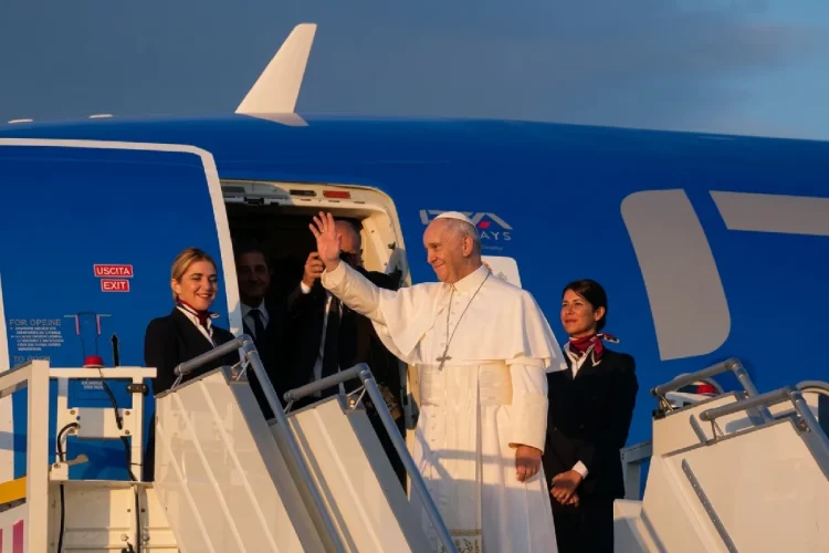Papa Francesco saluta dall'aereo con assistenti di volo