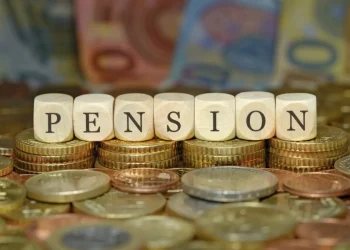 Cubi di legno compongono la parola PENSION su monete euro.