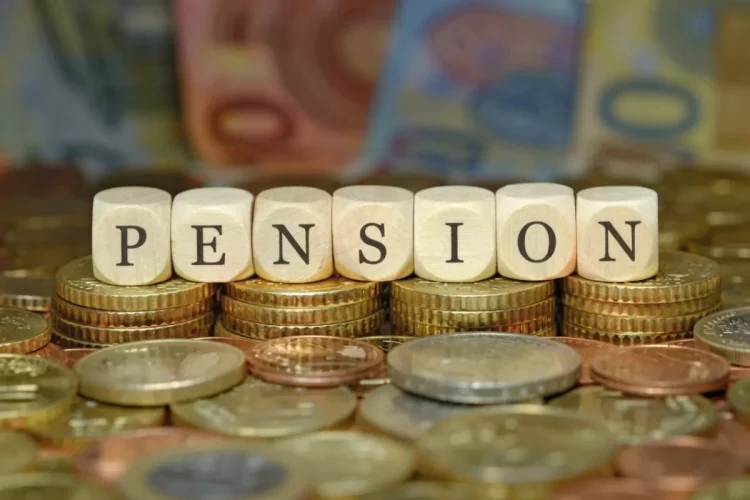 Cubi di legno compongono la parola PENSION su monete euro.