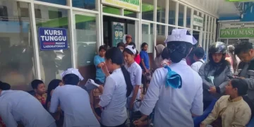 Studenti indonesiani ricevono assistenza medica in un ospedale affollato.