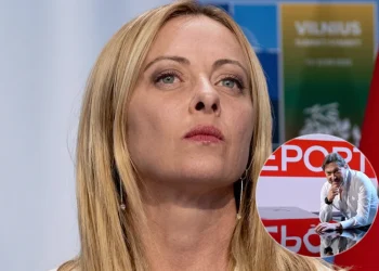Giorgia Meloni con espressione seria e Sigfrido Ranucci pensieroso nello studio di Report.