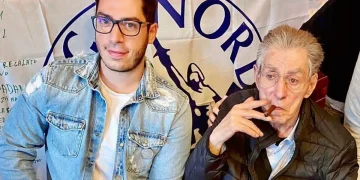Renzo Bossi e Umberto Bossi seduti insieme, il padre fuma un sigaro.