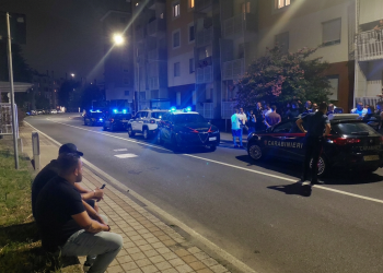 Carabinieri intervengono di notte su una strada a Rozzano, residenti osservano. Rozzano, dodici ore di aggressioni contro gli stranieri dopo il ferimento di una donna