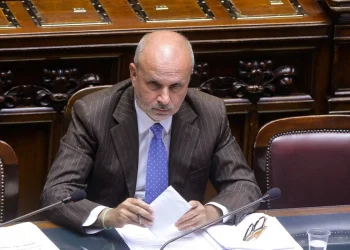 Orazio Schillaci, Ministro della Salute, seduto al tavolo con microfono