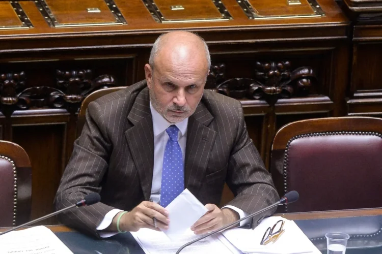 Orazio Schillaci, Ministro della Salute, seduto al tavolo con microfono