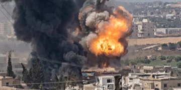 Fiamme e fumo nero dopo esplosione in un deposito di armi.
