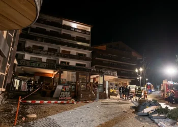 Vigili del fuoco in un villaggio alpino illuminato di notte