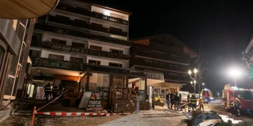 Vigili del fuoco in un villaggio alpino illuminato di notte