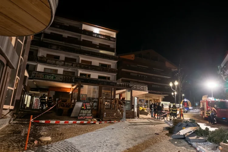 Vigili del fuoco in un villaggio alpino illuminato di notte