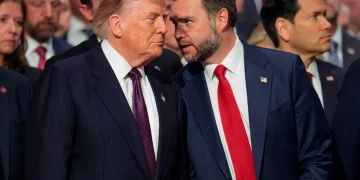 Donald Trump e J.D. Vance in conversazione ravvicinata, abiti scuri.