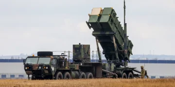 Sistema missilistico Patriot su veicolo militare in campo, un soldato.