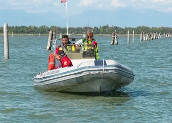 Operatori di soccorso a bordo di un gommone, navigano nella laguna veneta.