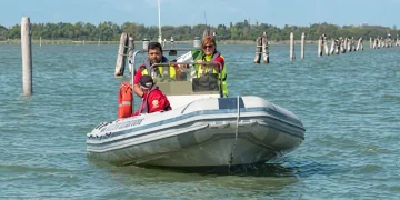 Operatori di soccorso a bordo di un gommone, navigano nella laguna veneta.