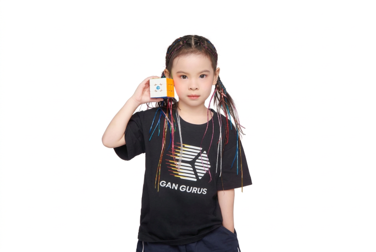 Bambina con trecce colorate tiene un cubo di Rubik bianco. Cubo di Rubik, bambina di 6 anni detiene il record mondiale femminile di risoluzione